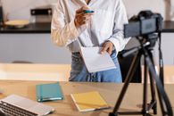 Person in White Long Sleeve Shirt and Blue Denim Jeans Holding White Paper