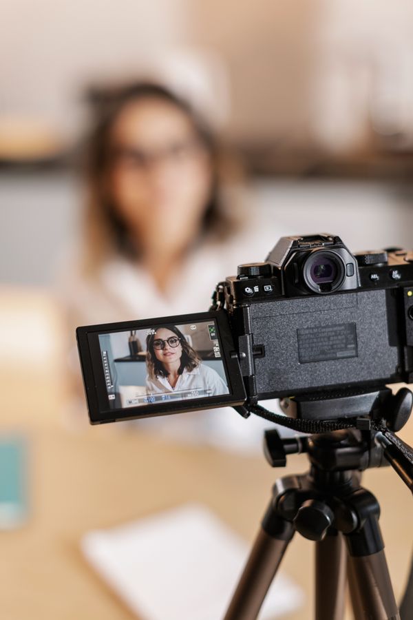 Creator filming with a DSLR at home — photo by Alena Darmel on Pexels