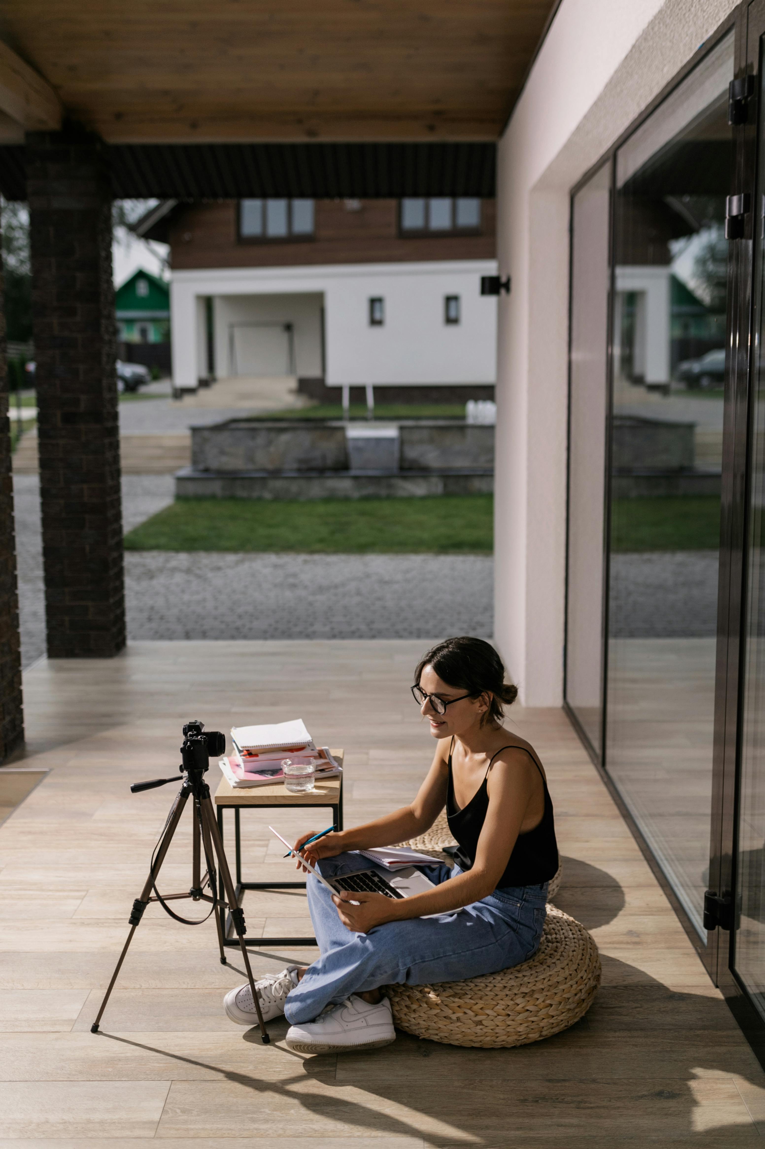 a woman sitting on a cushion while attending an online class