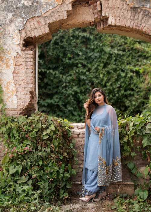 Femme En Robe Bleue Debout Près De Briques De Béton Marron