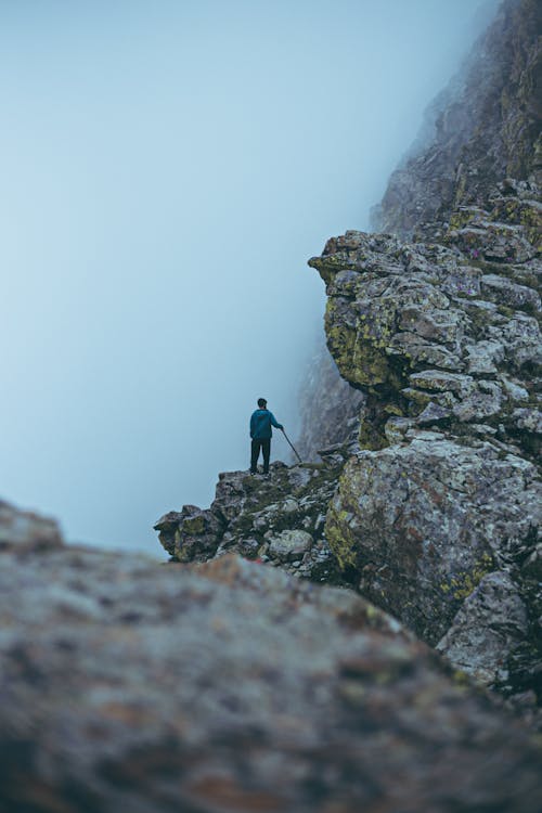 Free A Person Standing on a Cliff Stock Photo