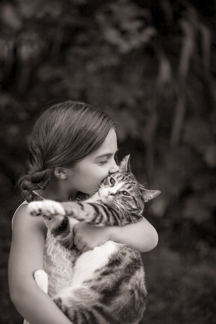 Grayscale Photo Of A Girl Kissing A Cat