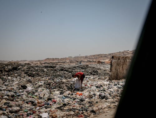 Free Person in Red Shirt Standing on Landfill Stock Photo