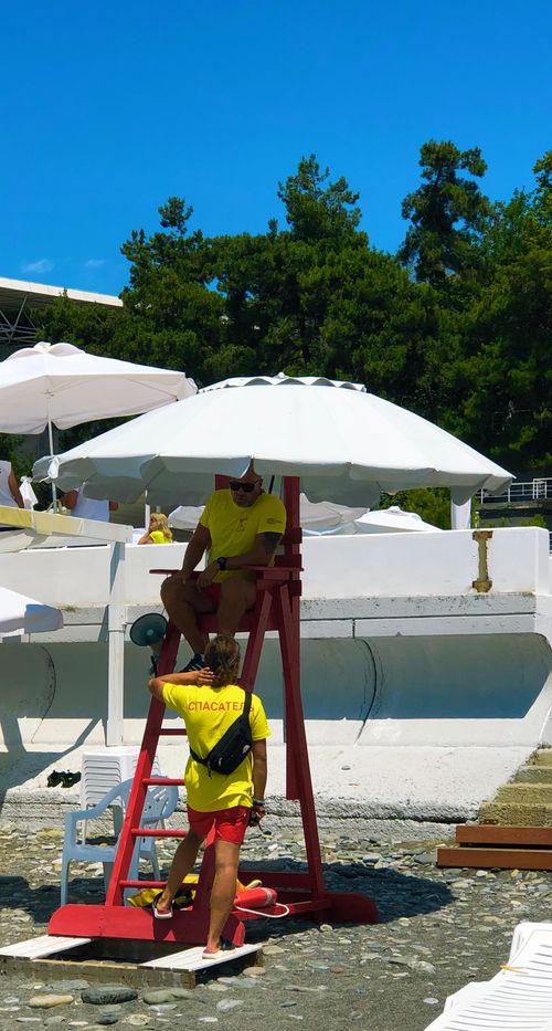 Free Lifeguards in bright uniforms overseeing safety on Sochi's sunny beach. Stock Photo