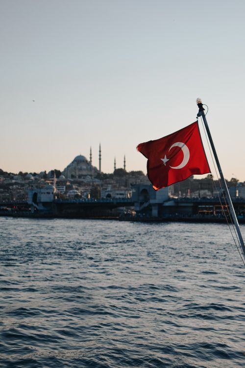 Free Turkish flag against Istanbul skyline during sunset, showcasing iconic mosques. Stock Photo