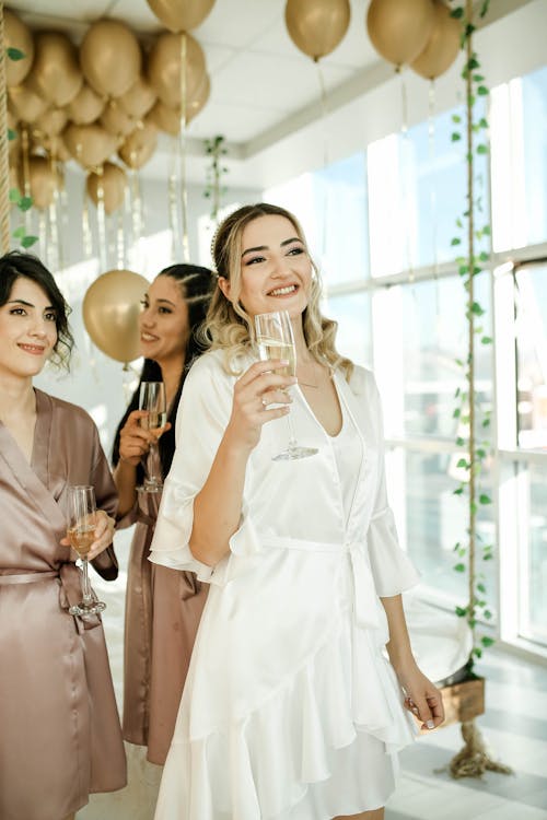 Bride and Bridesmaids Drinking Champagne at Party