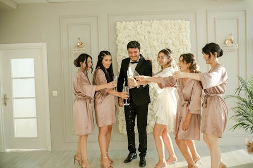 Bride, Groom and the Bridesmaids Clinking Champagne Glasses