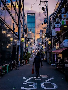 夜晚，一个人走在繁华的城市小巷里，四周环绕着发光的灯光和现代建筑