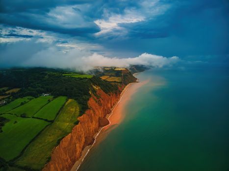 Aerial view of Sidmouth's stunning cliffs and coastline at sunset, England.