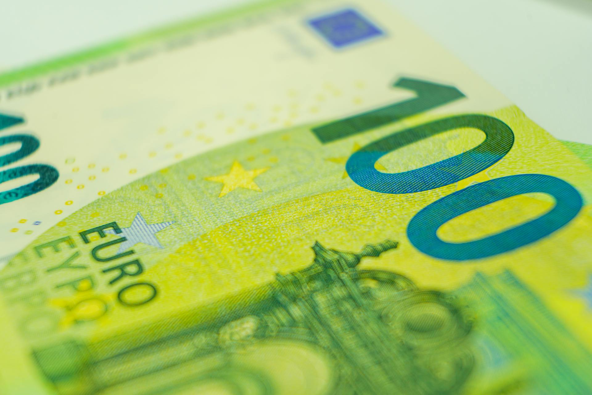 Detailed close-up of a 100 euro banknote showcasing currency details.