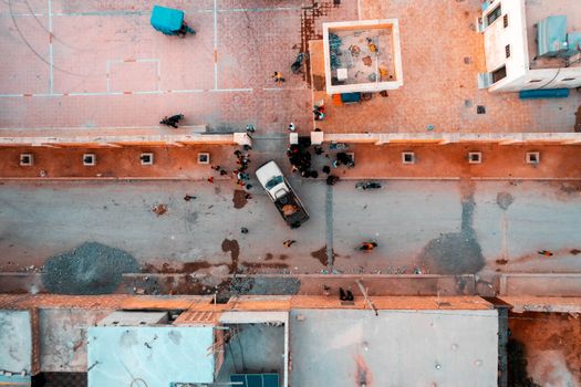 Drone shot capturing a bustling city street from above with vehicles and pedestrians.