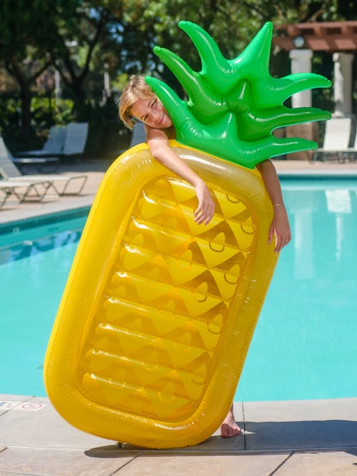 Kid Holding a Floater Standing Beside the Swimming Pool