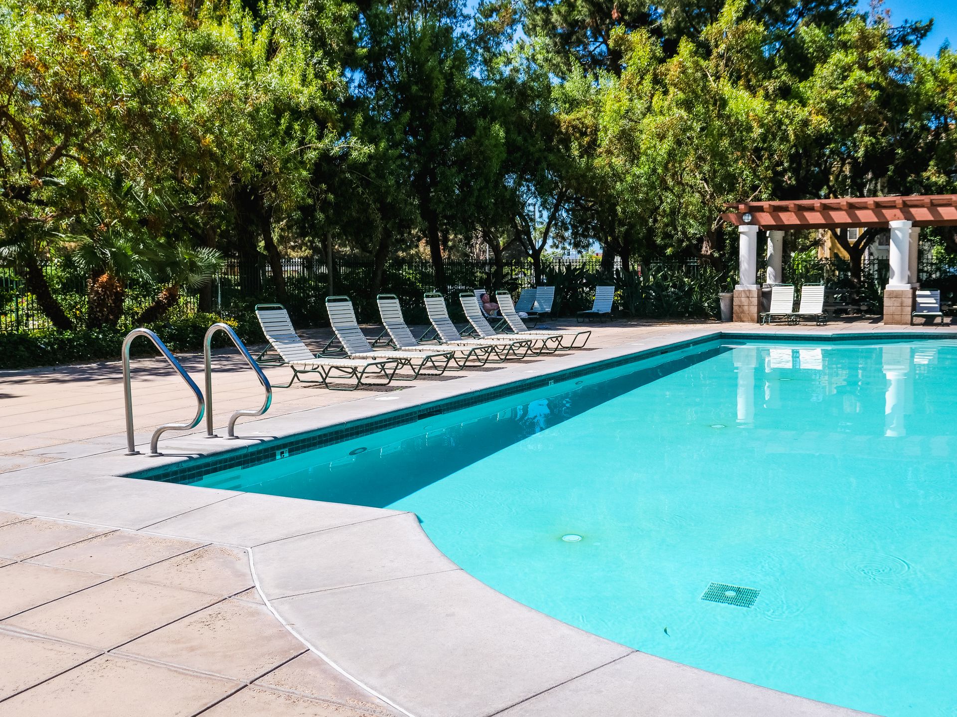 Swimming Pool Near Green Trees With Outdoor Lounge Chairs