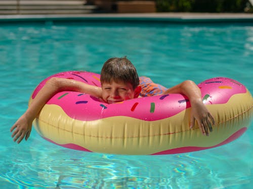 Free Kid Lying on a Floater Floating in a Poolho Stock Photo