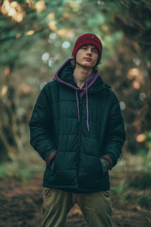 Man Wearing a Red Beanie Standing Under a Tree