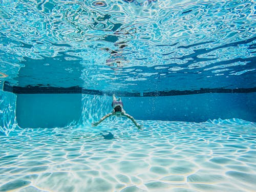 Man in Blue Shorts Swimming in Pool