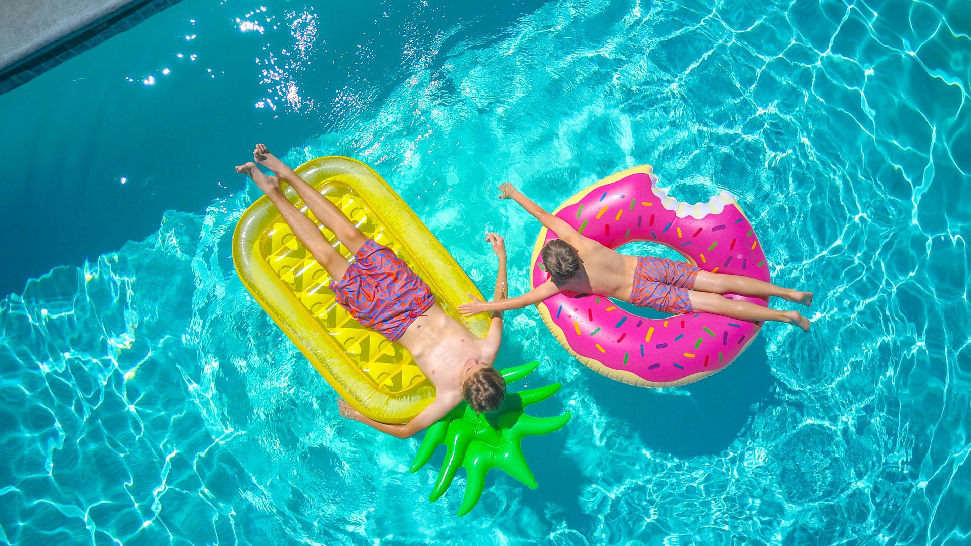 Boys Lying on Inflatable Floaters on the Swimming Pool