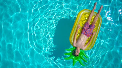 Free Boy Lying on a Floater in the Swimming Pool Stock Photo