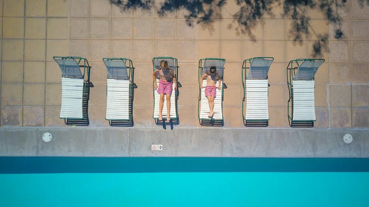 Boys Lying On Pool Chairs