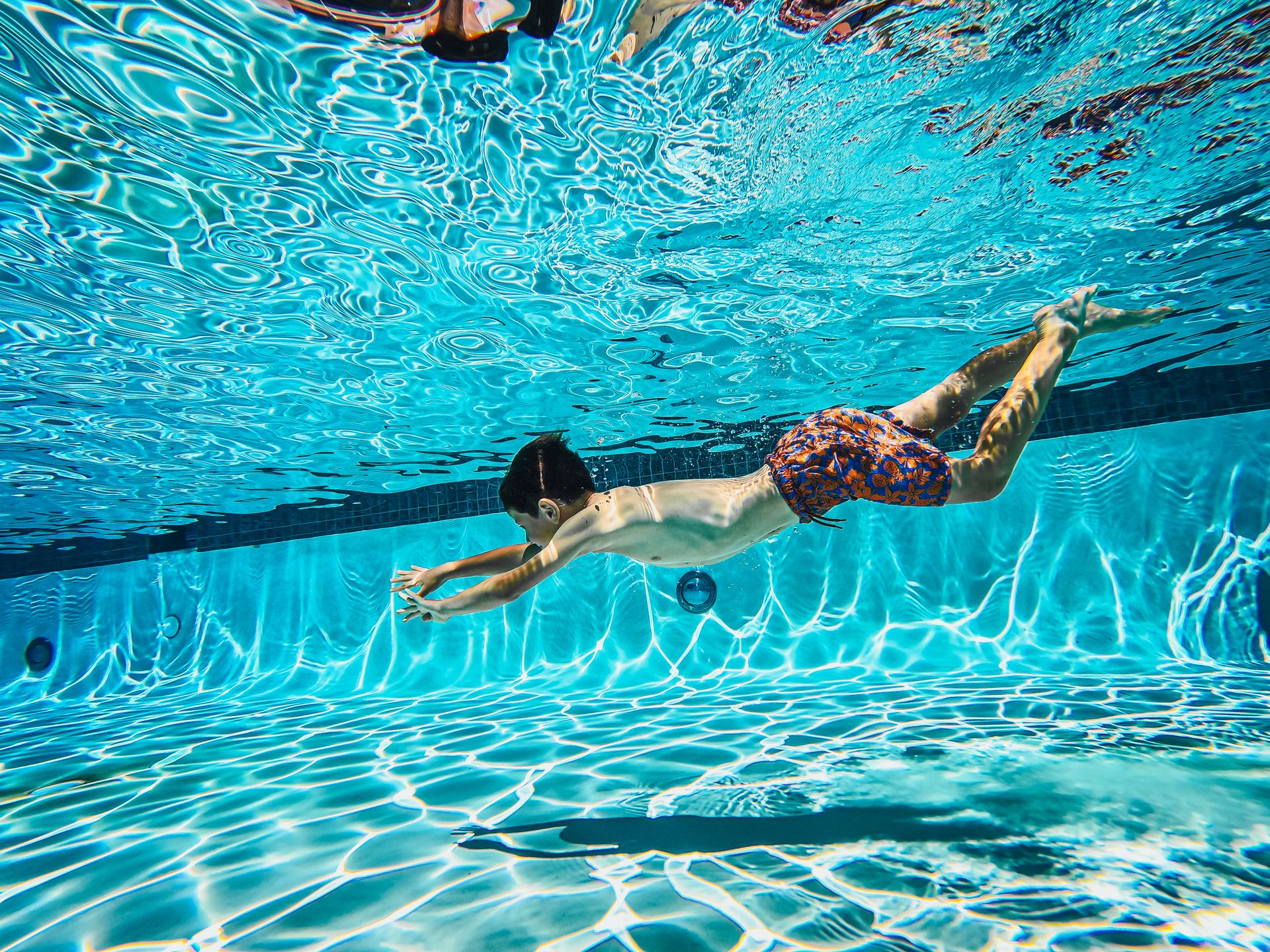 Kids Swimming Underwater in a Pool