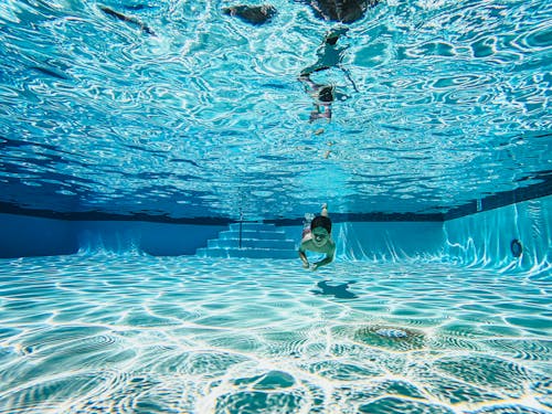 Free Kid Swimming Under a Pool Stock Photo