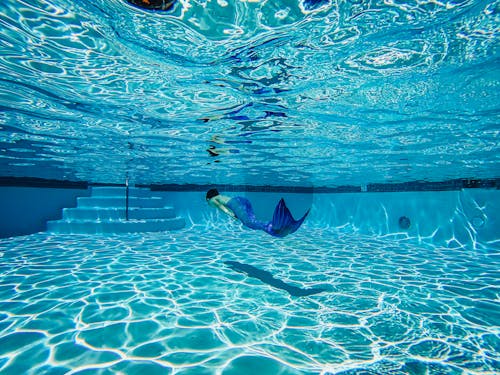 Person Wearing a Mermaid Suit Swimming Underwater