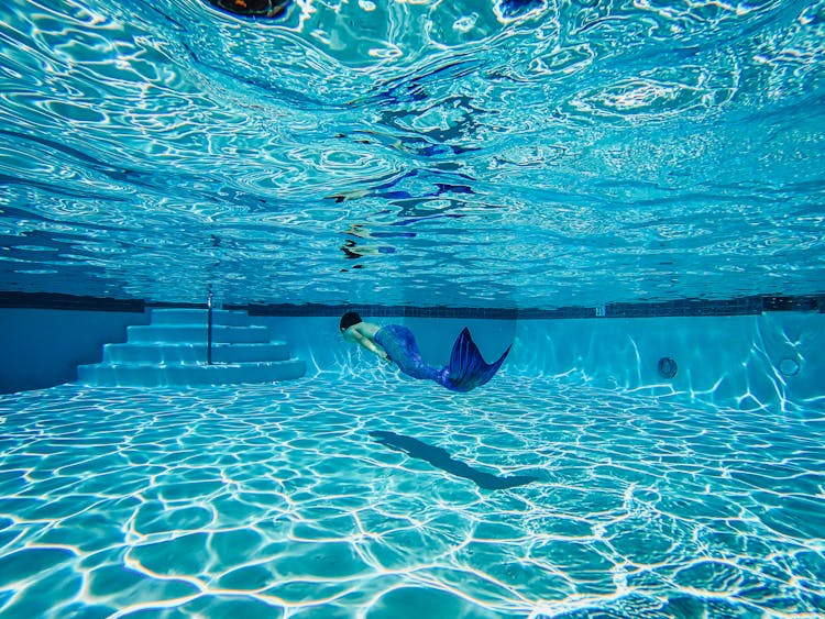 Person Wearing A Mermaid Suit Swimming Underwater