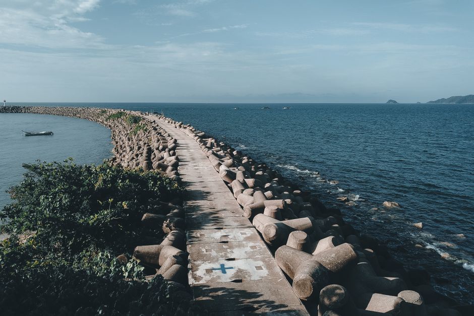 Serene view of a breakwater pathway extending into the sea at Marang, Malaysia.
