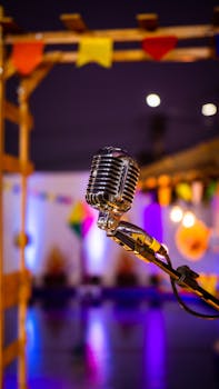 A classic microphone on stage with vibrant colors and lights in the background, capturing a lively event atmosphere.