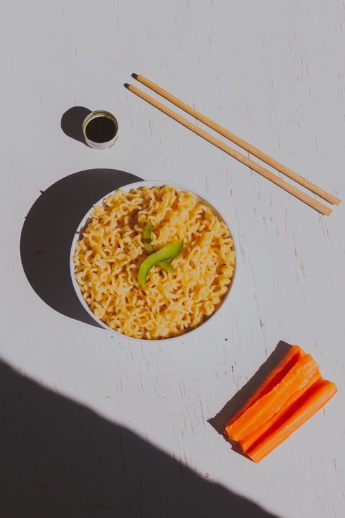 Free Delicious Asian noodles in a bowl with chopsticks, perfect for food enthusiasts. Stock Photo