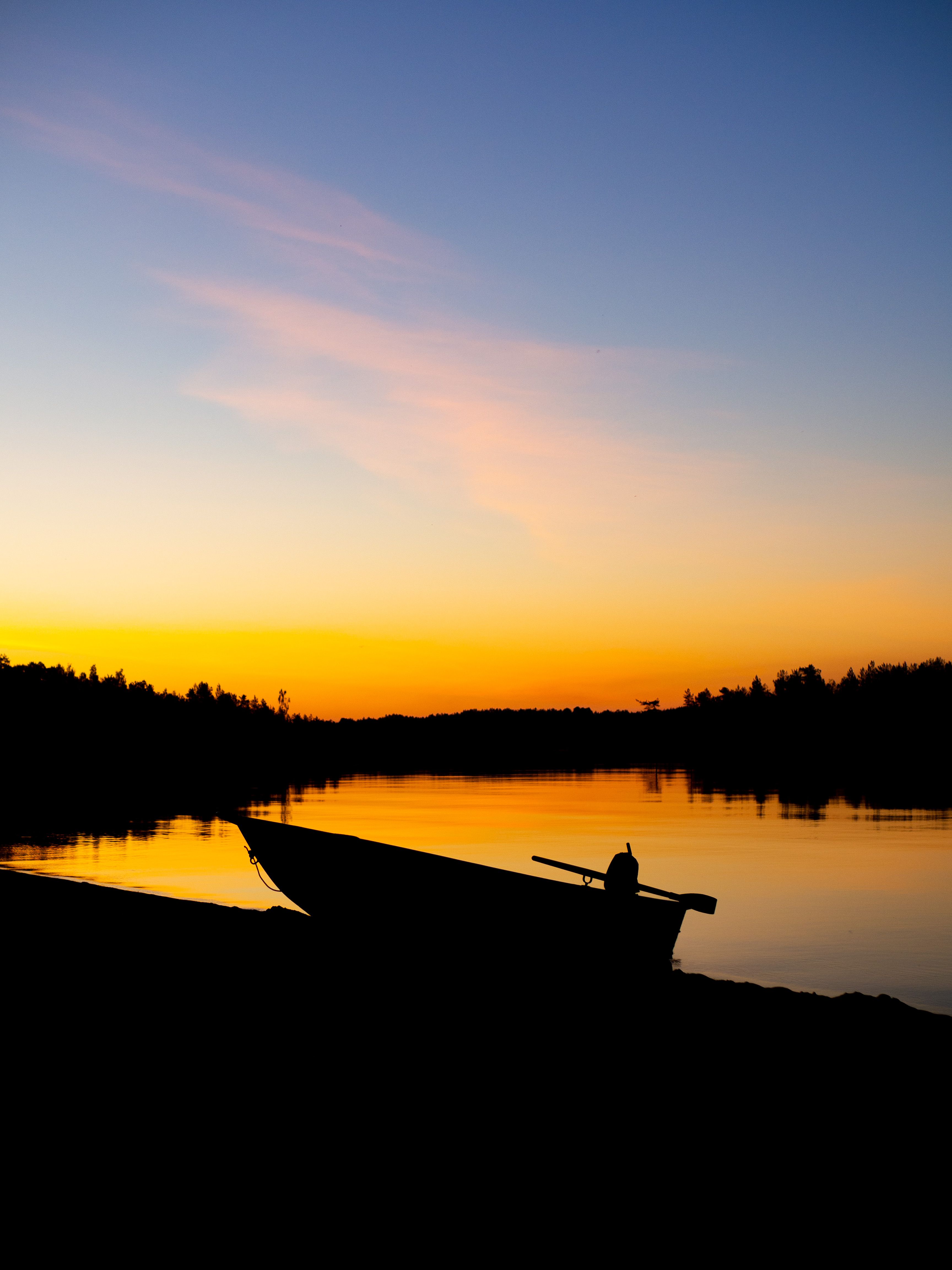 Silhouette of Man Inside of Boat Sailing on Body of Water during Sunset ...
