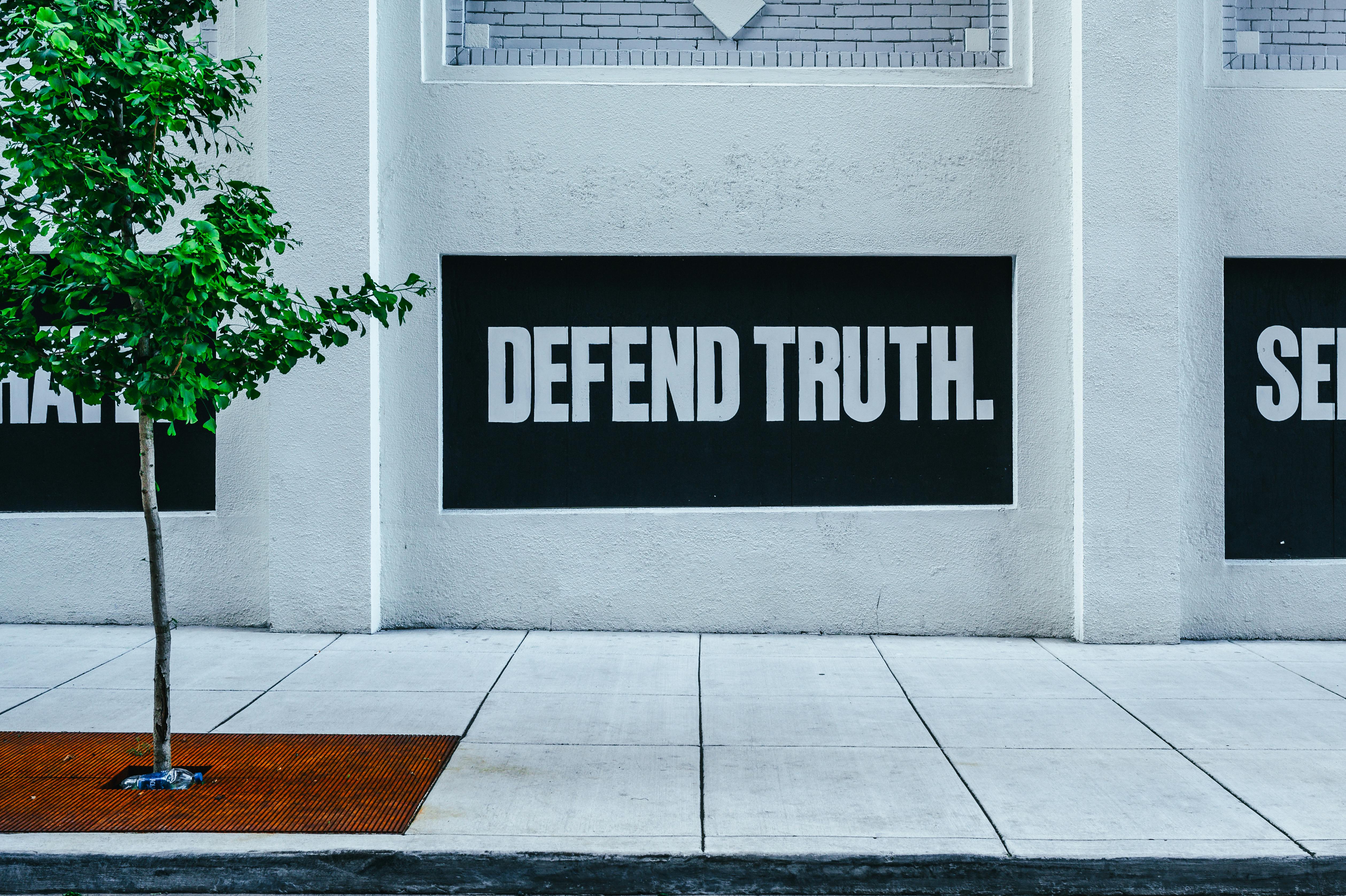 Street wall with message 'Defend Truth' reflects powerful expression and urban vibe.
