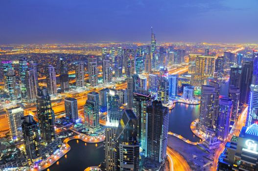 Stunning aerial view of Dubai Marina's illuminated skyscrapers and vibrant cityscape at night.