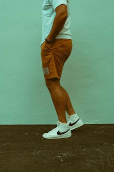 Side view of a person wearing urban streetwear with white Nike sneakers.