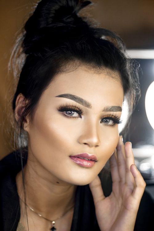 Free Close-up portrait of a woman with professional makeup and styled hair, exuding confidence and elegance. Stock Photo