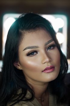 Stunning close-up portrait of a young woman with elegant makeup.
