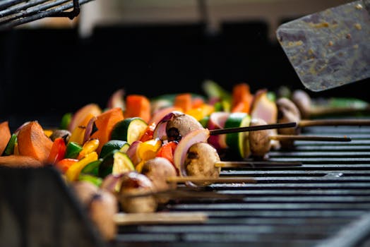 Close-up of vibrant veggie skewers grilling outdoors, ideal for barbecue or food photography.