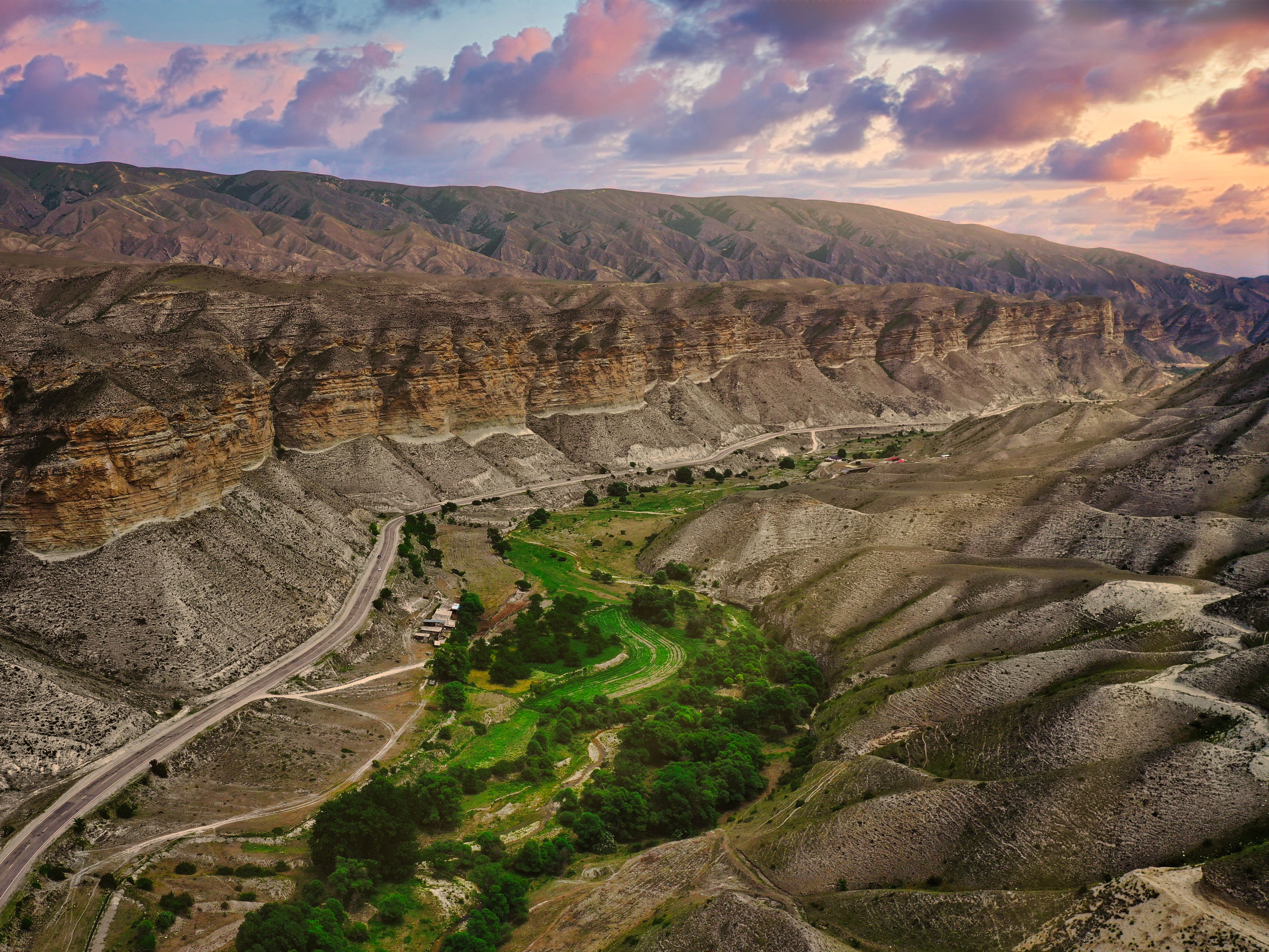 A breathtaking aerial view of a canyon landscape in Dagestan under a vibrant sunset sky.