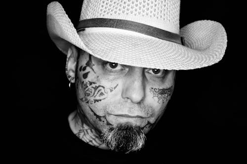 bezplatná Základová fotografie zdarma na téma chlap v tetování, detail, klobouk Základová fotografie