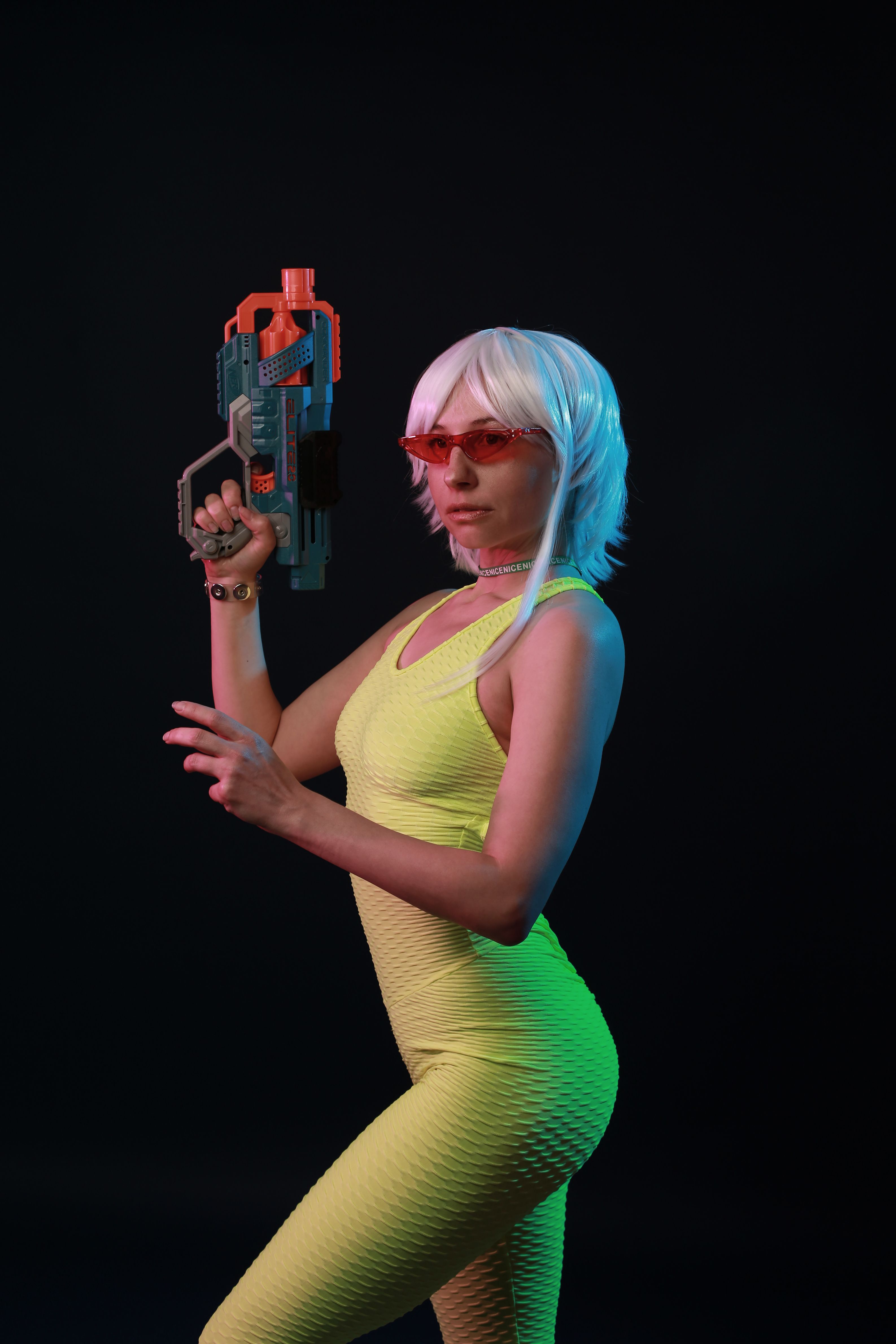 Femme en tenue de cosplay colorée dans un studio sombre