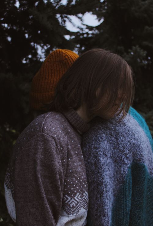 Free Two people embrace in warm sweaters, surrounded by autumn foliage, creating a cozy and serene vibe. Stock Photo