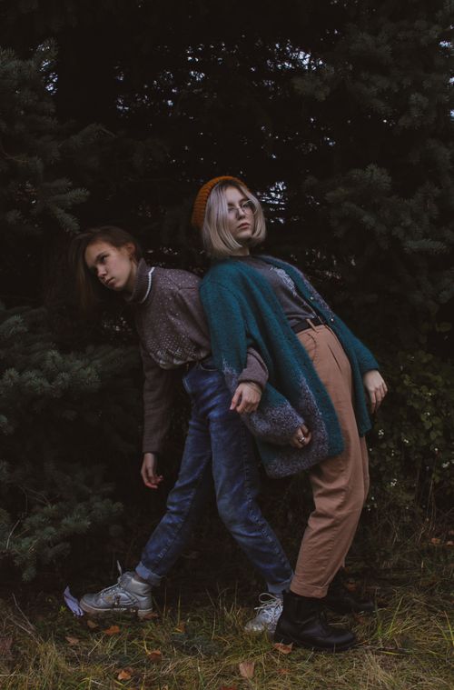 Free Two fashionable women posing outdoors in stylish autumn attire against a natural backdrop. Stock Photo