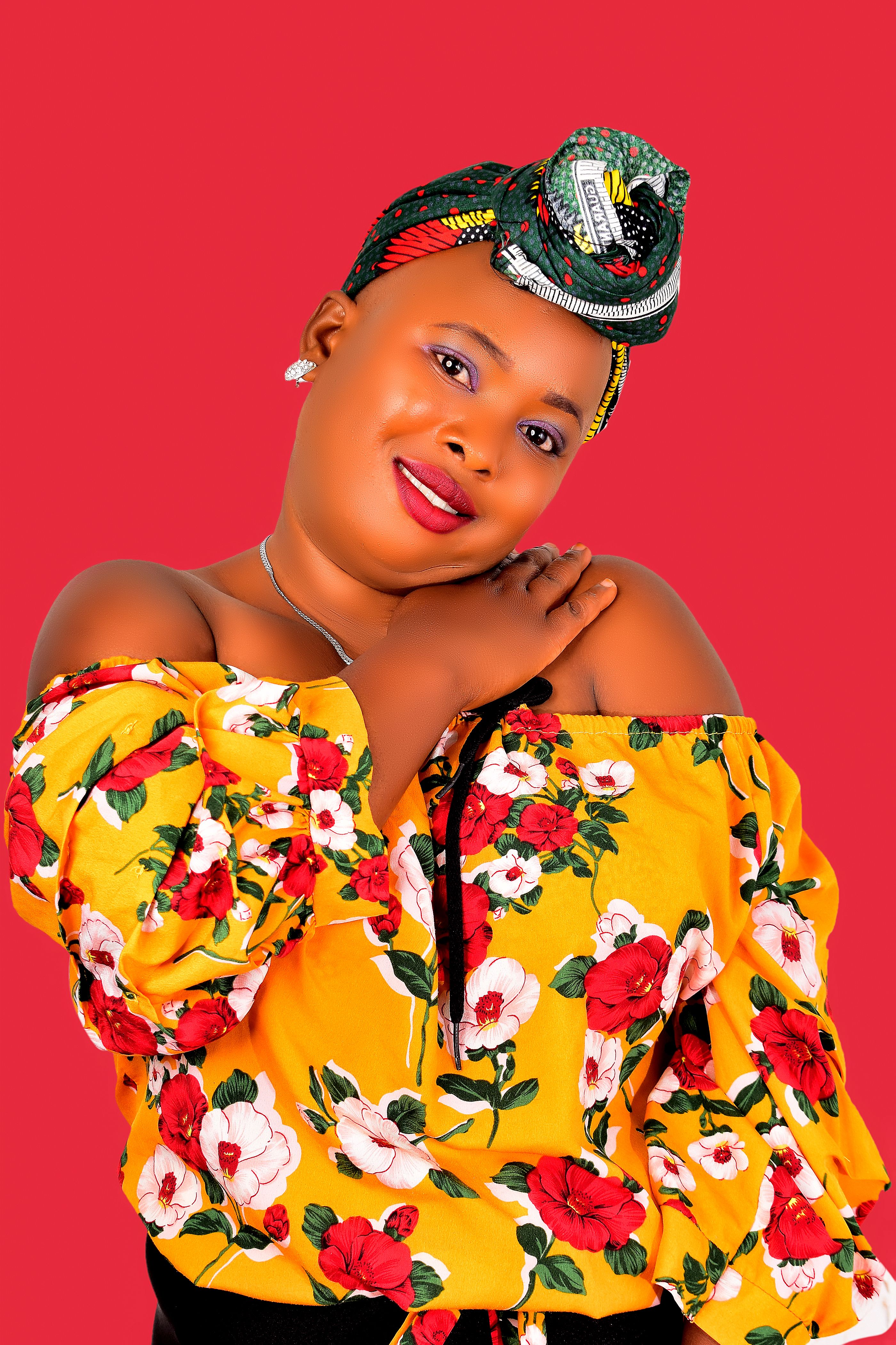 Colorful studio photoshoot featuring a stylish woman in floral attire, exuding joyful elegance.