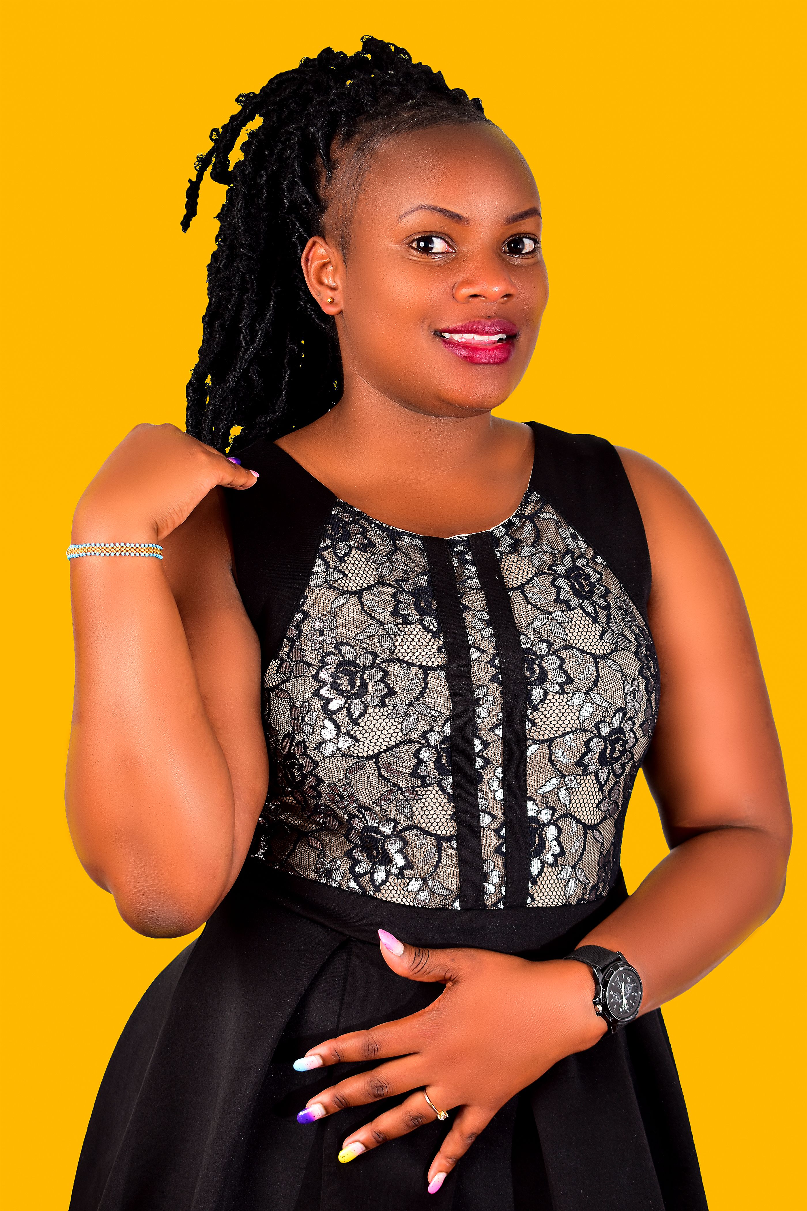 Portrait of a black woman confidently posing indoors against a vibrant yellow background. Studio shoot.