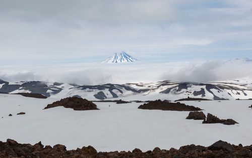 Free Majestic snow-covered landscape featuring a distant volcano under cloudy skies. Stock Photo