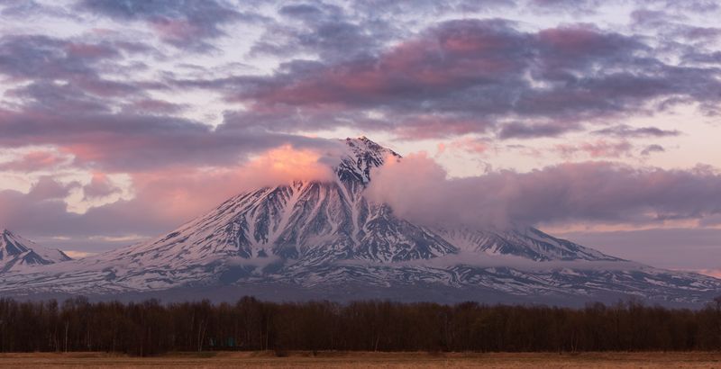 Snowcapped volcano beneath pink sunset clouds — photo by Alexander Maksin on Pexels
