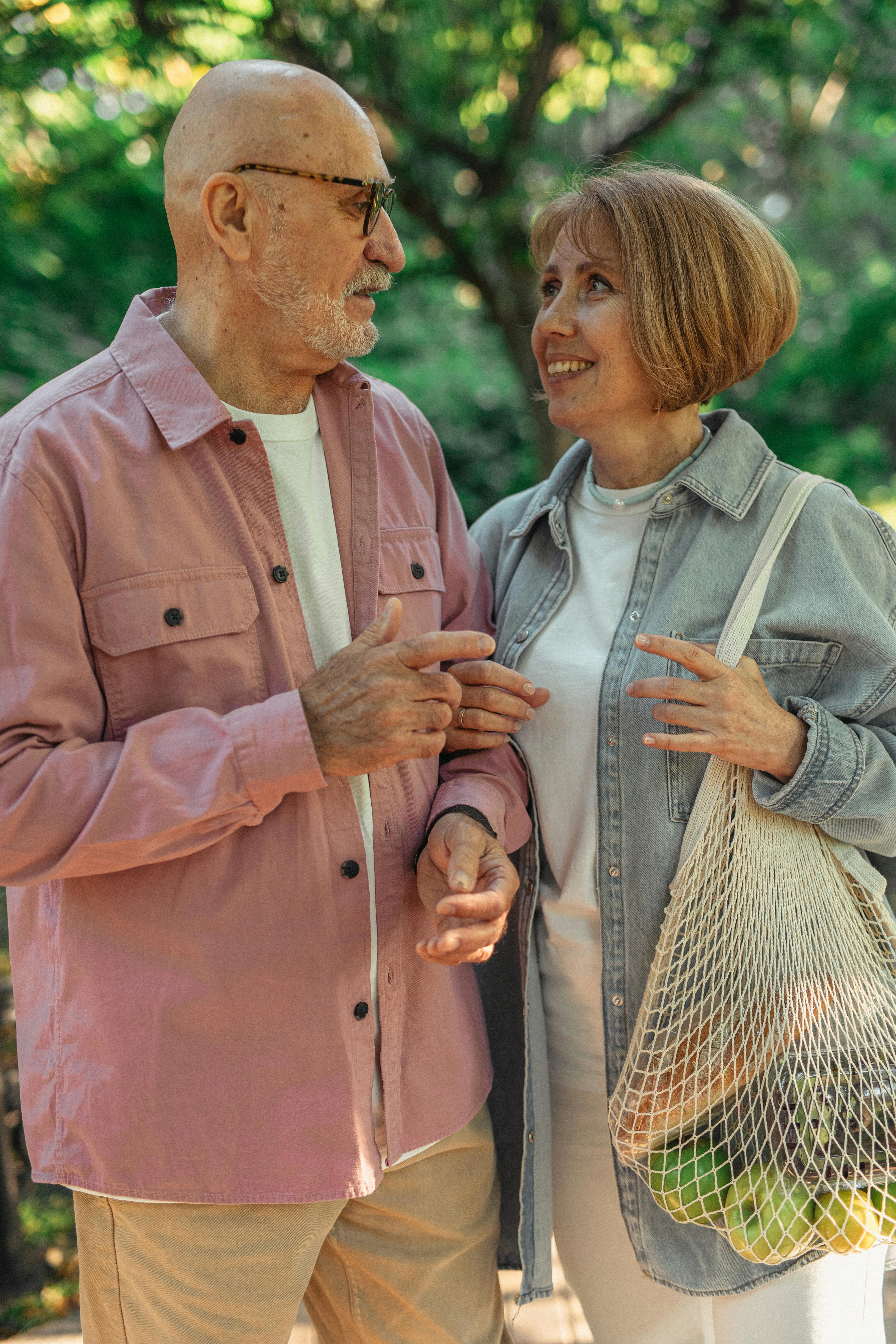 an elderly woman carrying a mesh bag with groceries