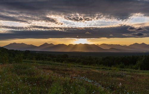 Green Grass Field Near Mountains During Golden Hour 