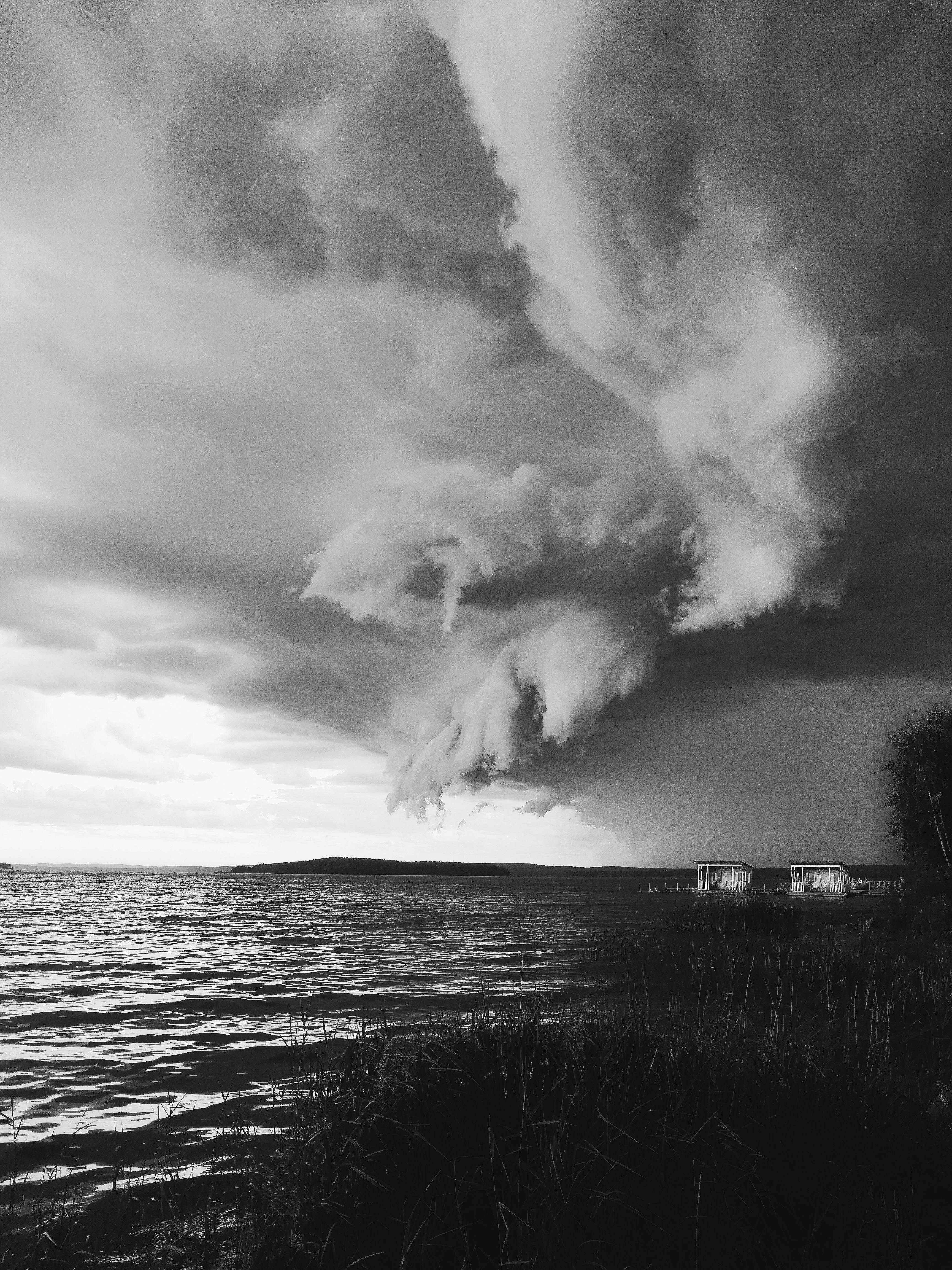 Moody clouds over a lake creating a dramatic black and white photography scene.