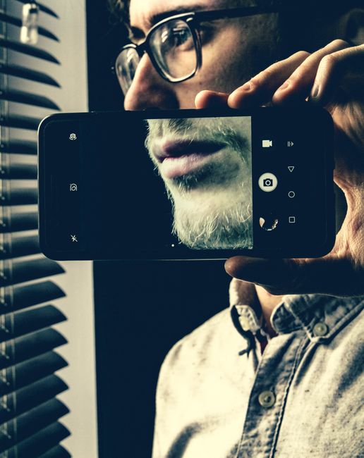 person looking at phone selfie